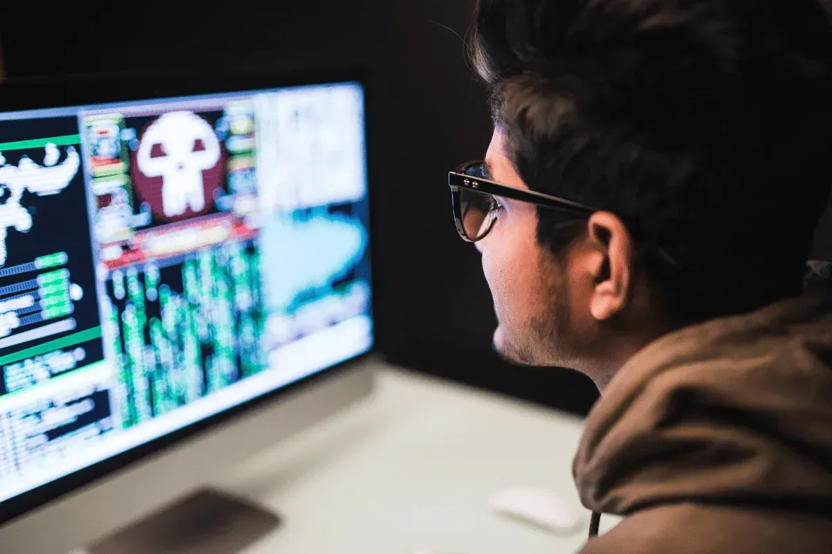 A person focused on a monitor displaying complex data and graphics, highlighting coding or cybersecurity information.