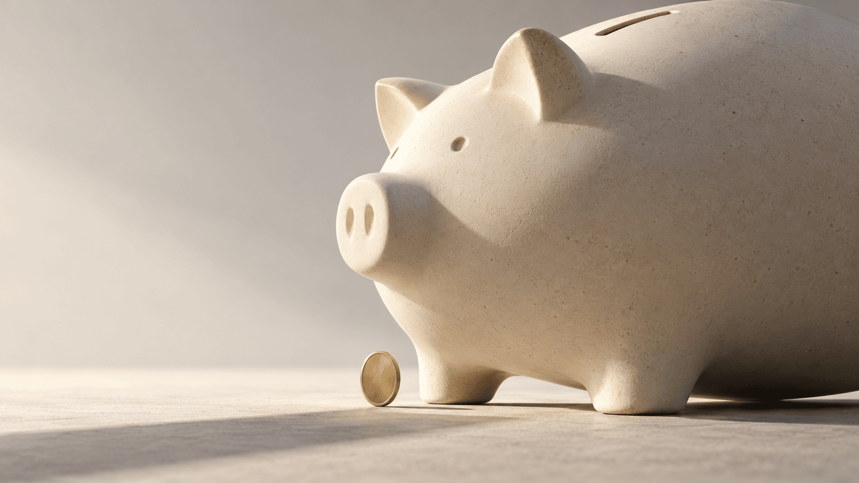 An ivory ceramic piggy bank beside a small brass coin, representing savings on AI creation.